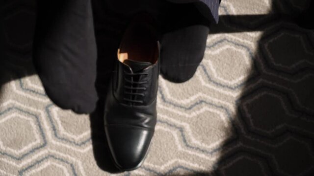 The young man put on the black shoes. Groom dresses for an event or wedding. High quality FullHD footage