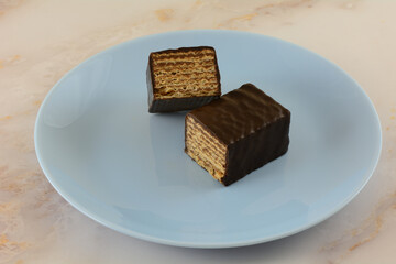 Dark chocolate almond layered wafer candy bar snack on blue plate