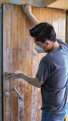 young man sanding wooden door