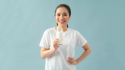 Woman drinking milk, happy and smiling beautiful young woman enjoying a glass milk