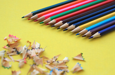 set of colored pencils for drawing on a yellow background