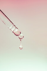 A drop of cosmetic oil falls from the pipette
