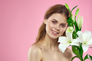Obraz na płótnie Canvas Portrait of woman with white flowers beautiful face pink background naked shoulders