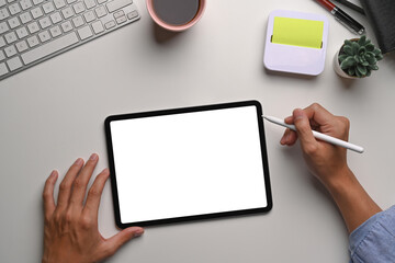 Above view of man designer holding stylus pen writing on digital tablet.