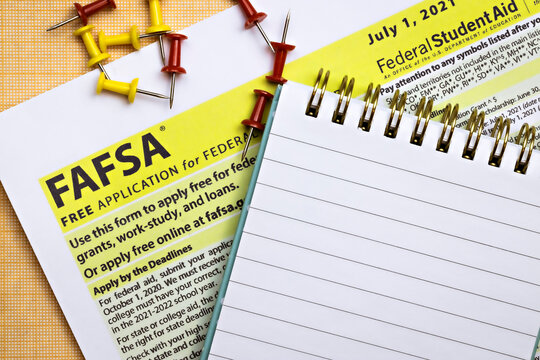topview photo of FAFSA - free application for federal student aid, and open notepad with blank space