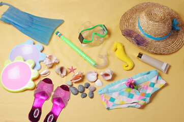 Obraz premium Beach accessories and seashells on a yellow background.