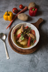 Top view of Healthy food chicken stew prepared along with vegetables in a bowl on a wooden platter
