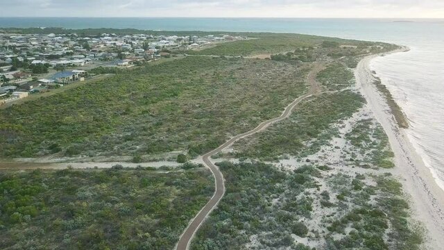 Panorama Of Lancelin With Town And Scenic Road Between Lush Trees Overlooking Sandy Beach In Western Australia. - Aerial Tilt-Up Shot