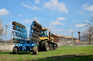 Fototapeta premium Agricultural tractor with equipment for working in field