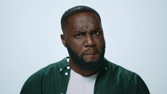 Portrait of thoughtful african american man posing on grey background.