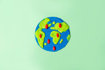 World Earth or Oceans Day. DIY and children creativity for ecological festive. Craft planet Earth from plasticine with red tears as crying and asks for help of pollution and global warming