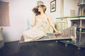A girl 16 y old is levitating on carpet and dreaming. 