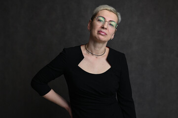 Portrait of caucasian blonde woman wearing glasses on gray background