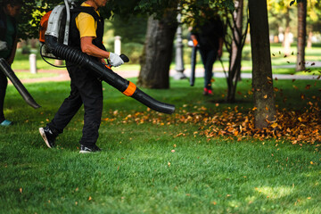 A woman operating a heavy duty leaf blower.