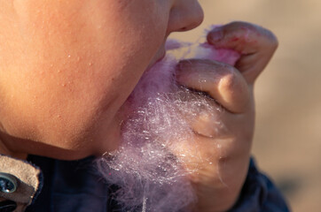 child eating cotton candy with hand