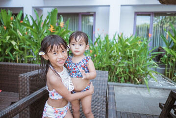 Fototapeta premium portrait of asian two girl in swim wear smiling looking at camera