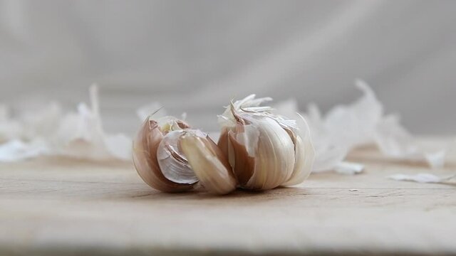 Crushing garlic on a wooden board.