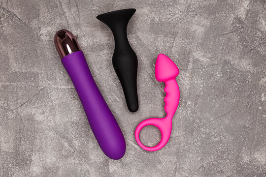 Sex toy for adult, dildo, vibrator on grey background. Place for text. Copy space. Flat lay. Sex shop concept. Design minimal dildo vibrator for clitoris. BDSM. Top view of vibrators. Safe love