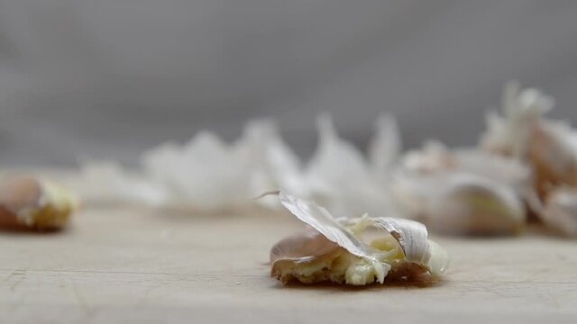 Crushing garlic on a wooden board.