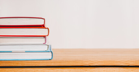 A stack of books on wooden table. Mock up with education and reading concept. Literature for learning, development and joy