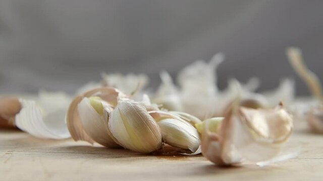 Crushing garlic on a wooden board.