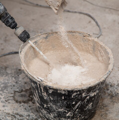 A worker kneads the mixture into plaster buckets. Home renovation