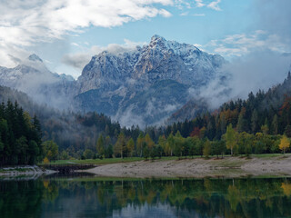 Lake Jasna's upper lake with mt. Prisojnik in the background, glooming in autumn weather and colours. Lake Jasna consists of two smaller artificial lakes in Kranjska Gora, Slovenia.