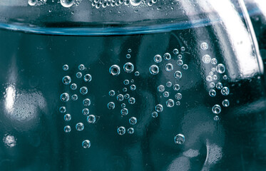 Naklejka na ściany i meble Water drops on a blue plastic bottle as a background.