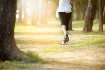 Half body runner woman legs wearing legging sport and sneaker women running In the forest park.