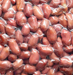 Close up of peanut nuts in a plastic bag as a background. Macro