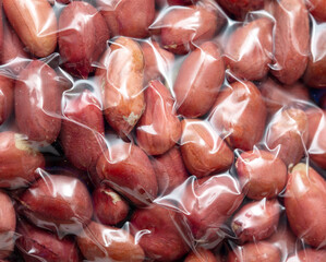 Close up of peanut nuts in a plastic bag as a background. Macro