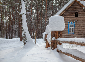 Large snow caps on the stumps of the fence in winter.