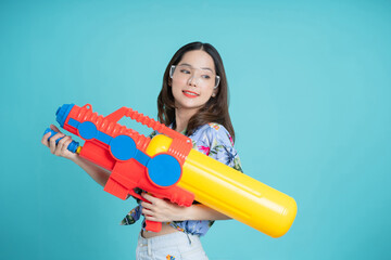 Beautiful woman holding water gun colorful on blue background