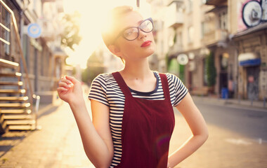 pretty woman with short hair and red lips on the street walk glass with drink