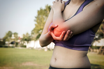 Woman holds a painful elbow