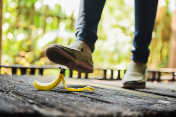 woman stepping on banana skin or peel, accident concept