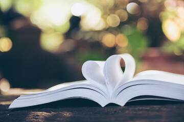 Heart from a book page against a beautiful sunset.