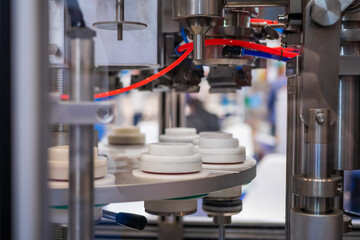 Automatic vacuum capping machine at packaging exhibition, trade show - close up view. Manufacturing, industry, automated technology equipment concept