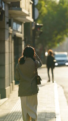 One pretty girl was posing to take picture on the street with the warm sunlight