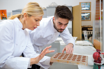 confectioners examining heart shaped chocolate moulds