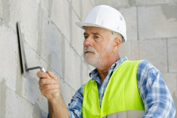 senior man working on wall construction © auremar