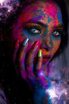 Indian fashion model with a bright colorful mix of paint on her face. Creative art make up. Holi concept, blue eyes. neon