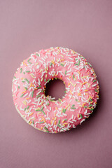 pink donut with sprinkles on pink background