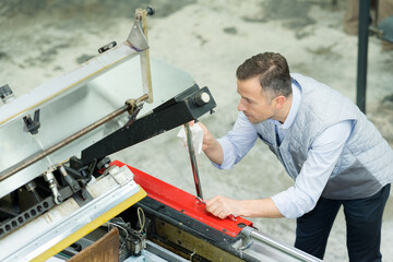engineer wiping part of industrial machine with rag