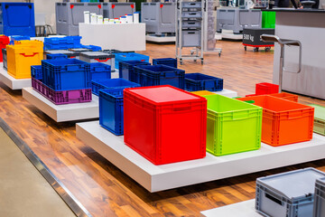 Many colorful plastic boxes, containers, crates at storage, warehouse, exhibition, trade show. Recycling, logistic and trade concept