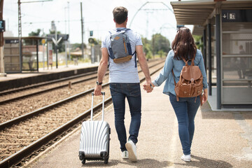 couple with traveling luggage at train station