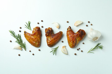 Baked chicken wings and spices on white background