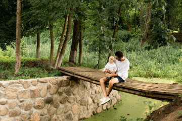 Fototapeta premium Happy man playing with his baby son outside on a sunny day