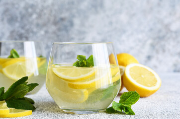 Fresh summer drink. Cold lemonade with mint on a concrete background.