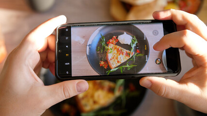 Male hands take photos of food of French quiche by modern smartphone. Closeup. 4K.